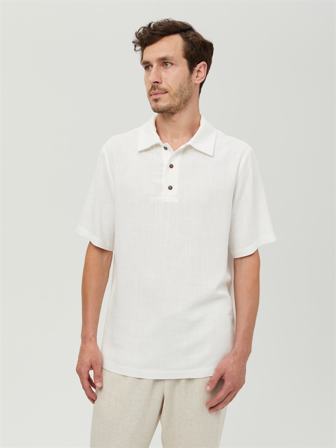 Мужская льняная футболка поло COSHENE, белая, вид спереди на модели в светлых брюках
