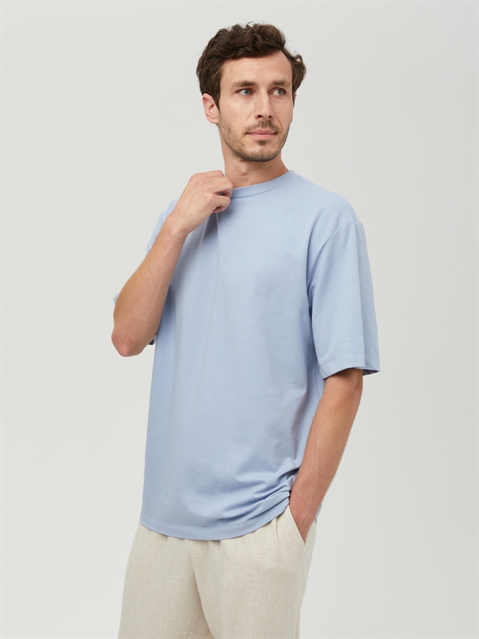 Мужская базовая футболка COSHENE, голубая, вид спереди на модели в светлых брюках
