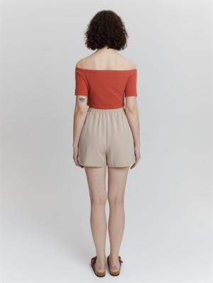 Бежевые женские шорты на резинке от COSHENE, вид сзади, сочетаются с топом со спущенными плечами
