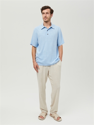 Голубая мужская футболка поло COSHENE, передний вид на модели в светлых брюках