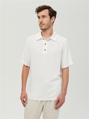 Мужская льняная футболка поло COSHENE, белая, вид спереди на модели в светлых брюках