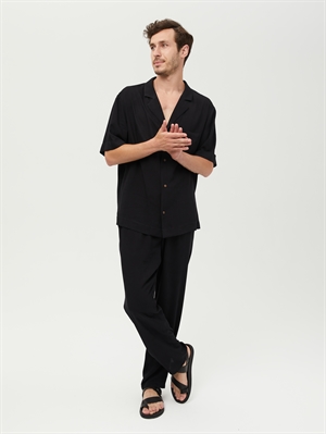 Летние брюки на резинке черного цвета от COSHENE, модель в расслабленной позе